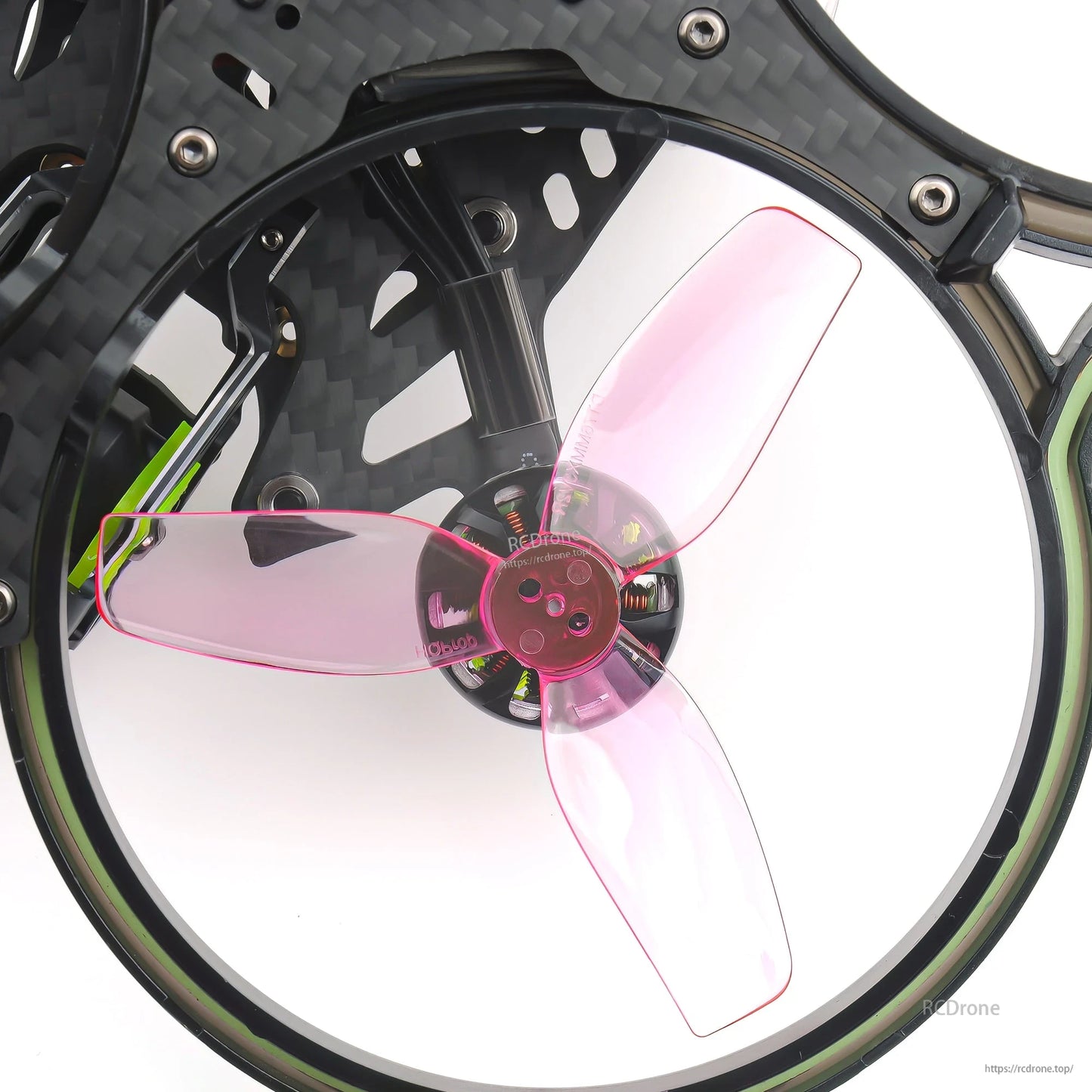 Transparent pink tri-blade prop mounted in cinewhoop duct guard, close-up of hub and blades