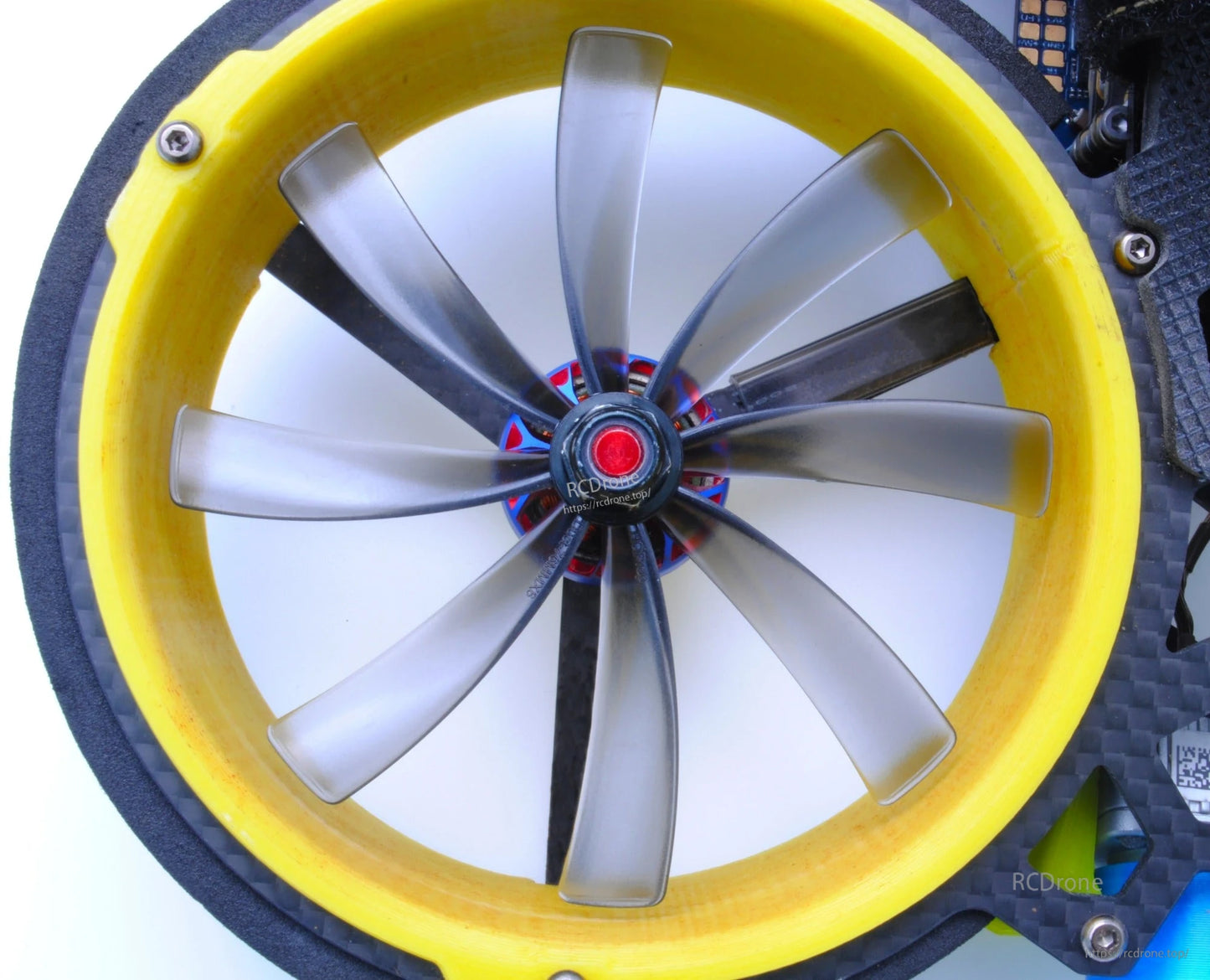 Close-up of grey 8-blade propeller mounted inside a yellow cinewhoop duct ring