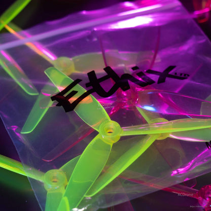 Ethix branded plastic bag with tri-blade propellers inside, neon lighting close-up