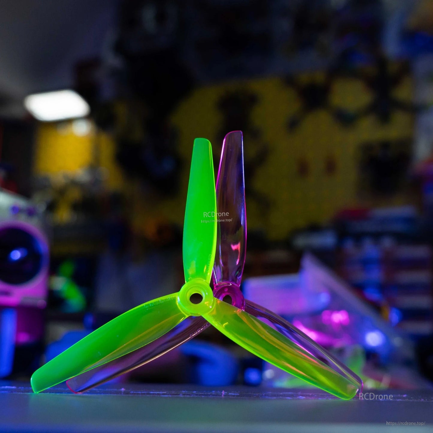Single tri-blade propeller standing upright, translucent green and purple blades, hub detail