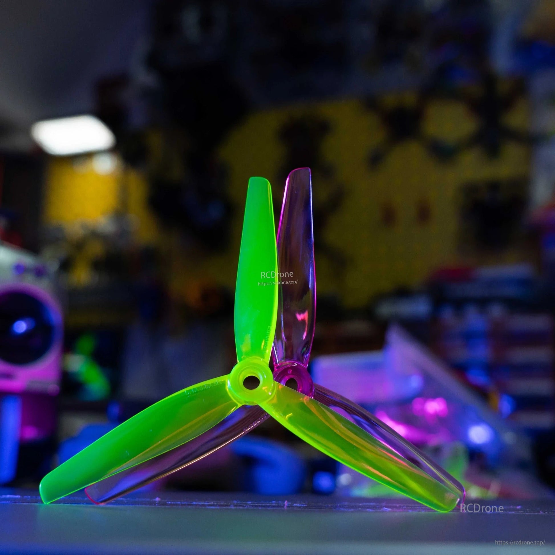 Single tri-blade propeller standing upright, translucent green and purple blades, hub detail