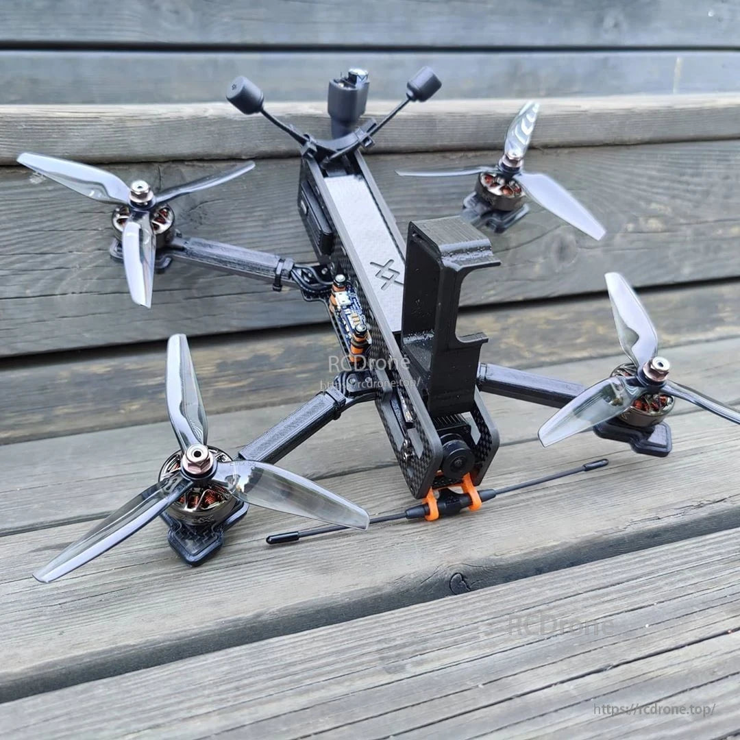 Light grey 3-blade propellers installed on an FPV quadcopter, top view on wooden steps
