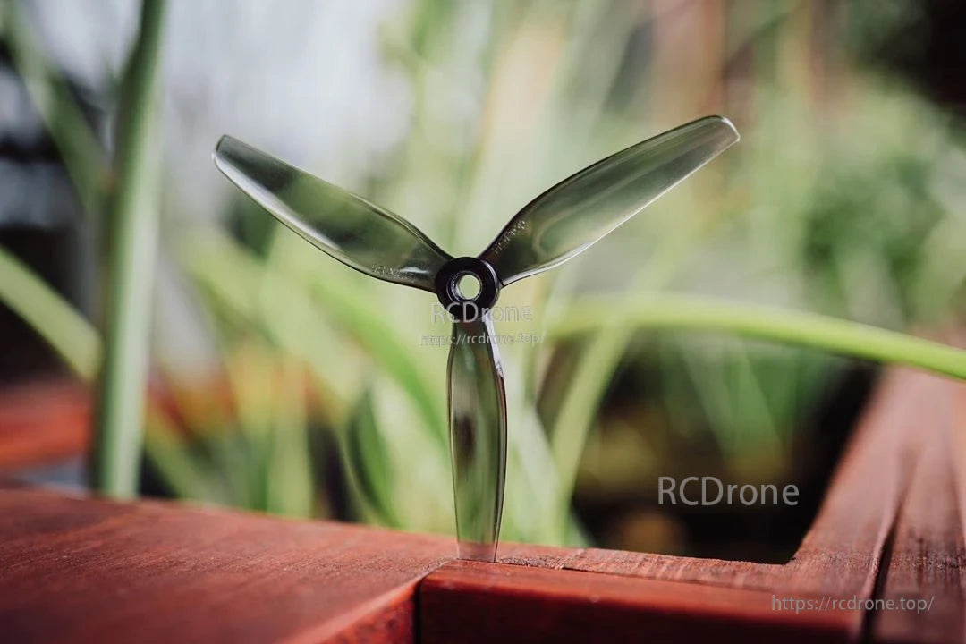 Single translucent light grey 3-blade FPV propeller standing upright, showing blade curvature and hub