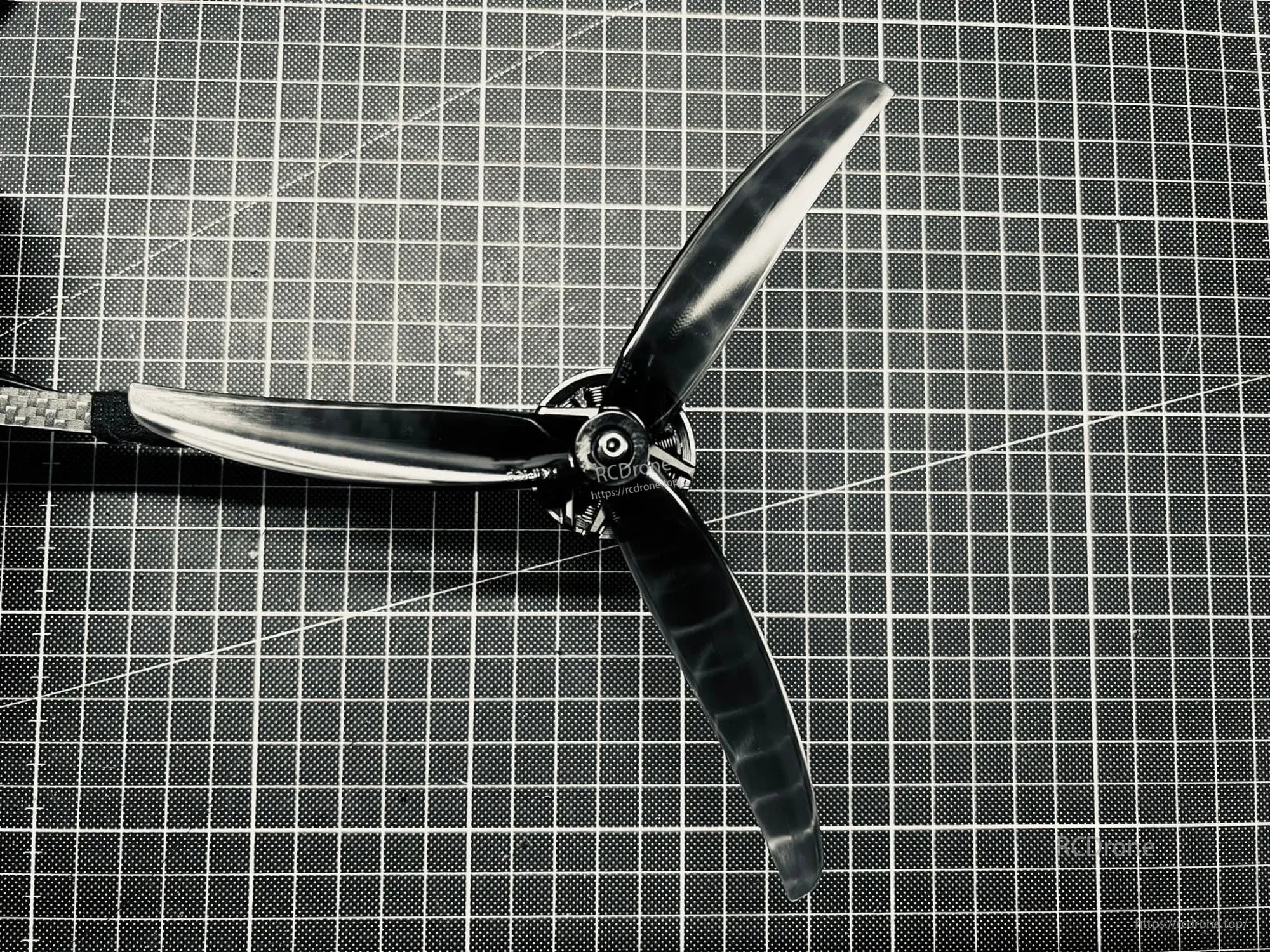HQProp J75 7X5X3 tri-blade propeller in light grey polycarbonate, close-up of hub and three blades