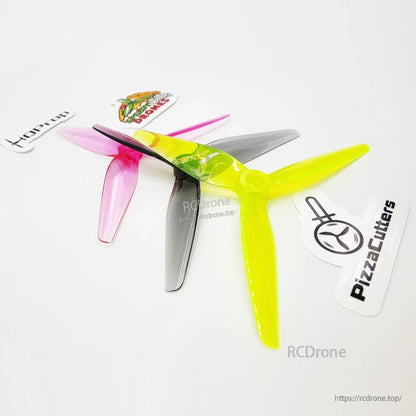 Angled close-up of stacked tri-blade propellers showing hub detail and translucent polycarbonate finish