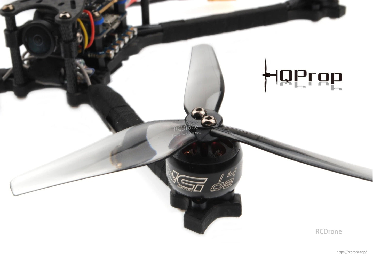Grey 3-blade propeller mounted on FPV drone motor, close-up of hub and mounting screw