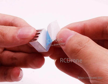 Peeling adhesive backing from thermal pad on small heatsink for installation