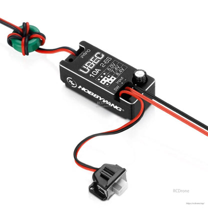 Hobbywing UBEC 10A 2–6S DC-DC regulator with red/black leads, ferrite ring, and 6.0/7.4/8.4V switch settings