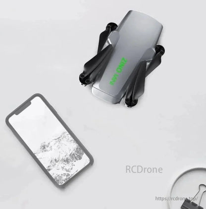 Orignal Hubsan Zino Mini Pro Drone Battery, A compact drone with folded propellers and a smartphone displaying a snowy landscape.
