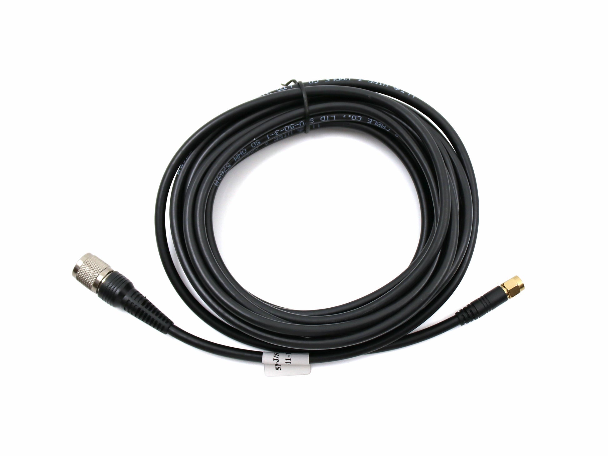 Coaxial antenna cable, coiled, TNC male to SMA male connector ends on white background