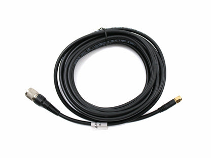 Coaxial antenna cable, coiled, TNC male to SMA male connector ends on white background