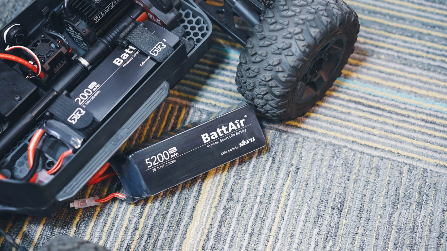 ISDT BattAir Smart 3S 5200mAh 80C LiPo battery pack with connector lead, next to an RC car chassis