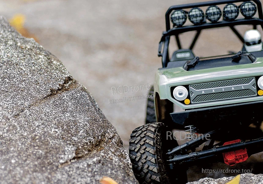 ISDT ESC, Front view of an Axial RC rock crawler truck on rough rocks with off-road tires and roof light bar