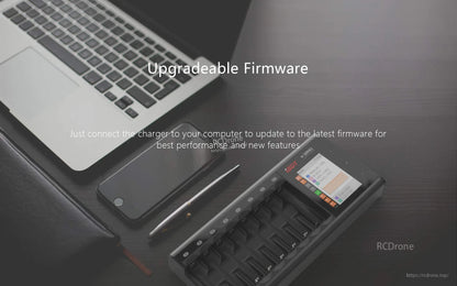 ISDT N16 Battery Charger, ISDT N16 multi-slot battery charger with display screen on a desk beside a laptop, promoting upgradeable firmware