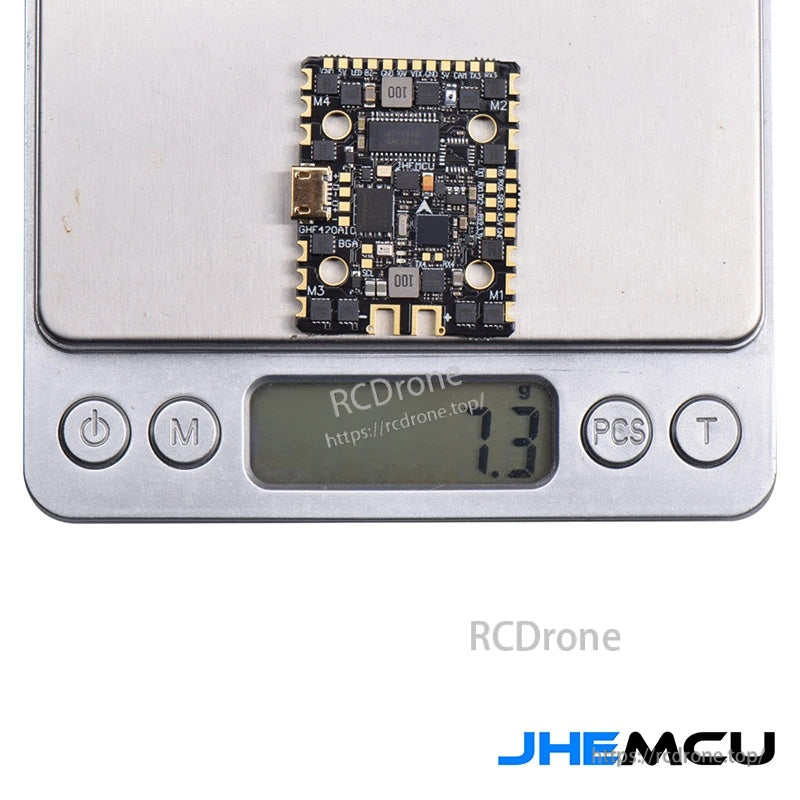 JHEMCU GHF420AIO-BGA AIO flight controller on digital scale showing 7.3 g board weight