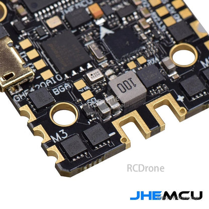 Close-up of flight controller corner showing motor pad, mounting hole, and inductor marked 001