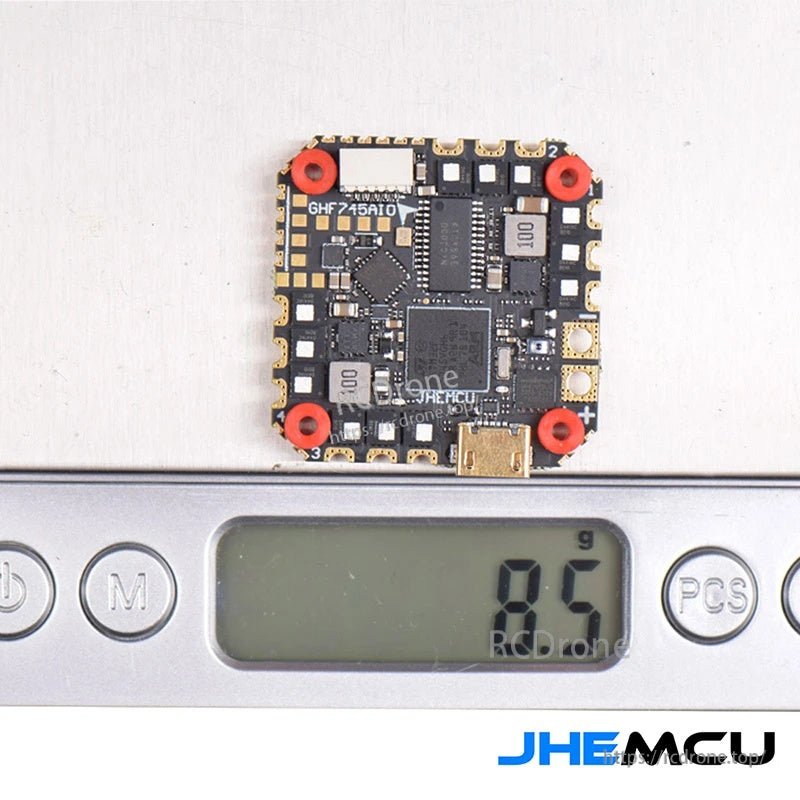 JHEMCU GHF745AIO board on a digital scale showing the lightweight AIO flight controller/ESC form factor
