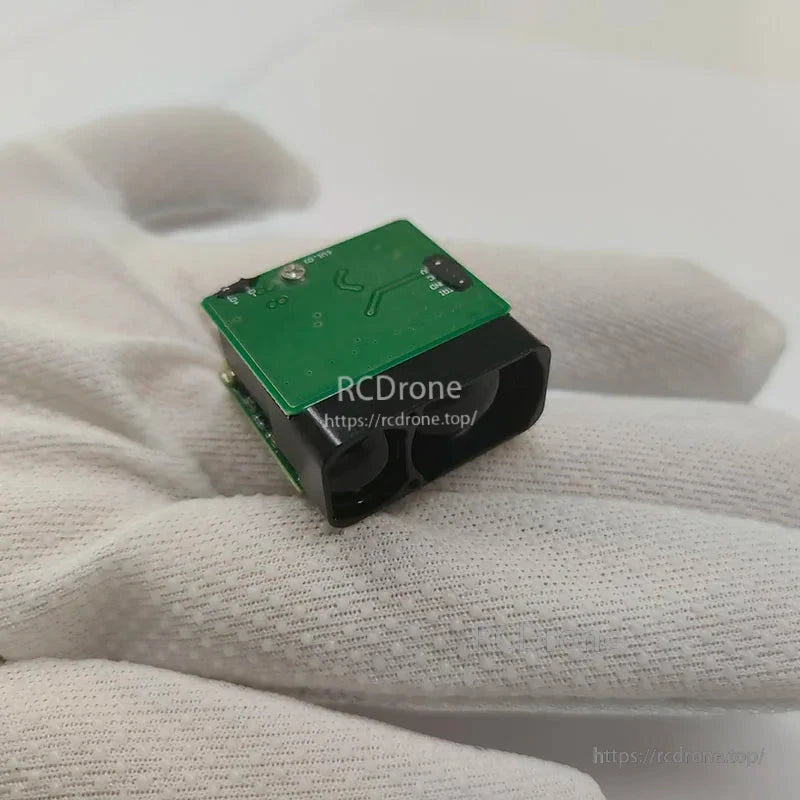 Green circuit board with black casing held gently