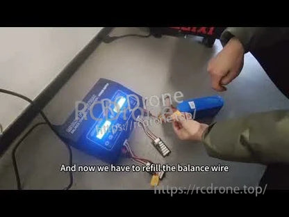 RC battery charger on a tabletop with connected balance lead and power connectors during battery setup
