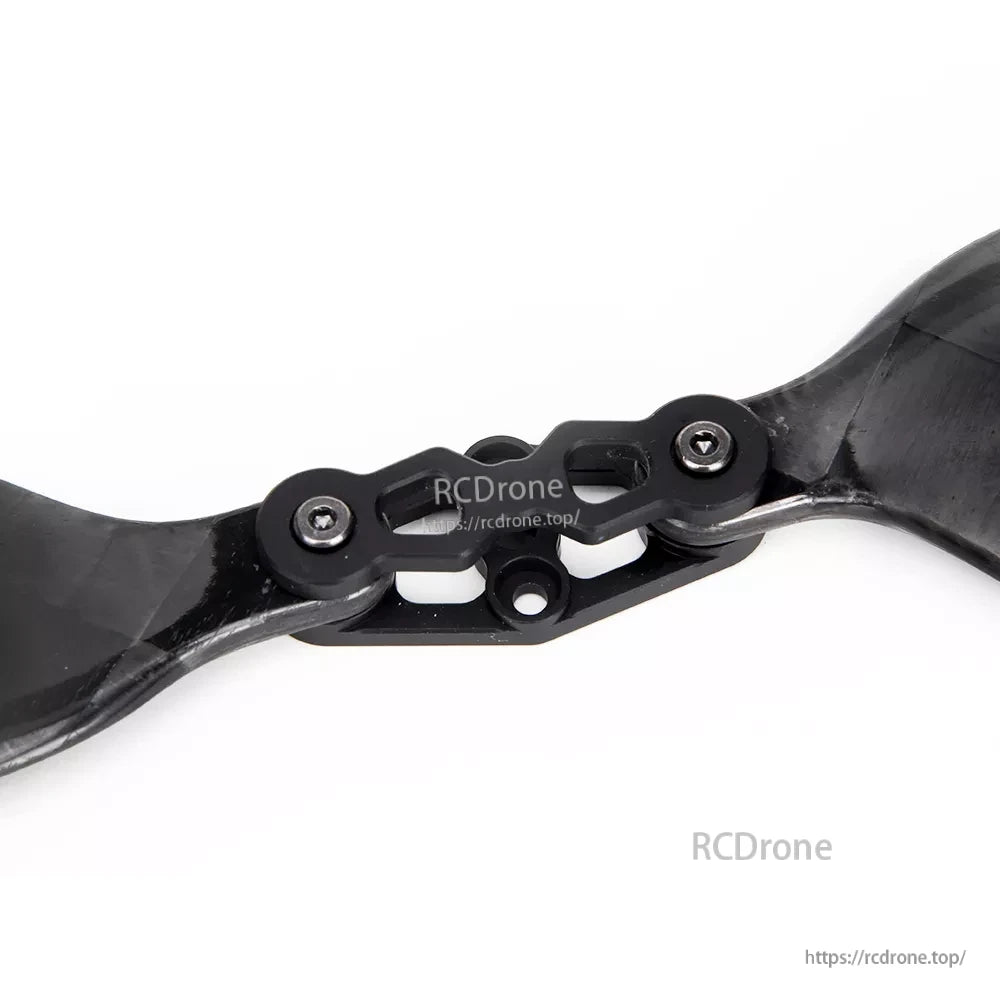 Close-up of a glossy carbon fiber folding propeller hub with bolted hinge and two blades