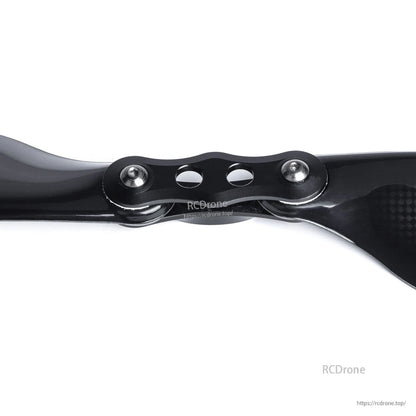 Close-up of MAD Components FLUXER Pro glossy carbon fiber folding propeller hub with bolts and two blades