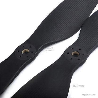 Pair of MAD FLUXER CB2 64x20 carbon fiber propeller blades with matte weave finish and multi-hole hubs