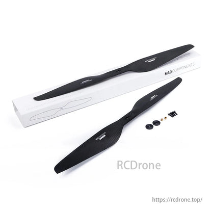 Two black carbon fiber propellers with mounting hardware, labeled "MAD COMPONENTS," are shown with their packaging.