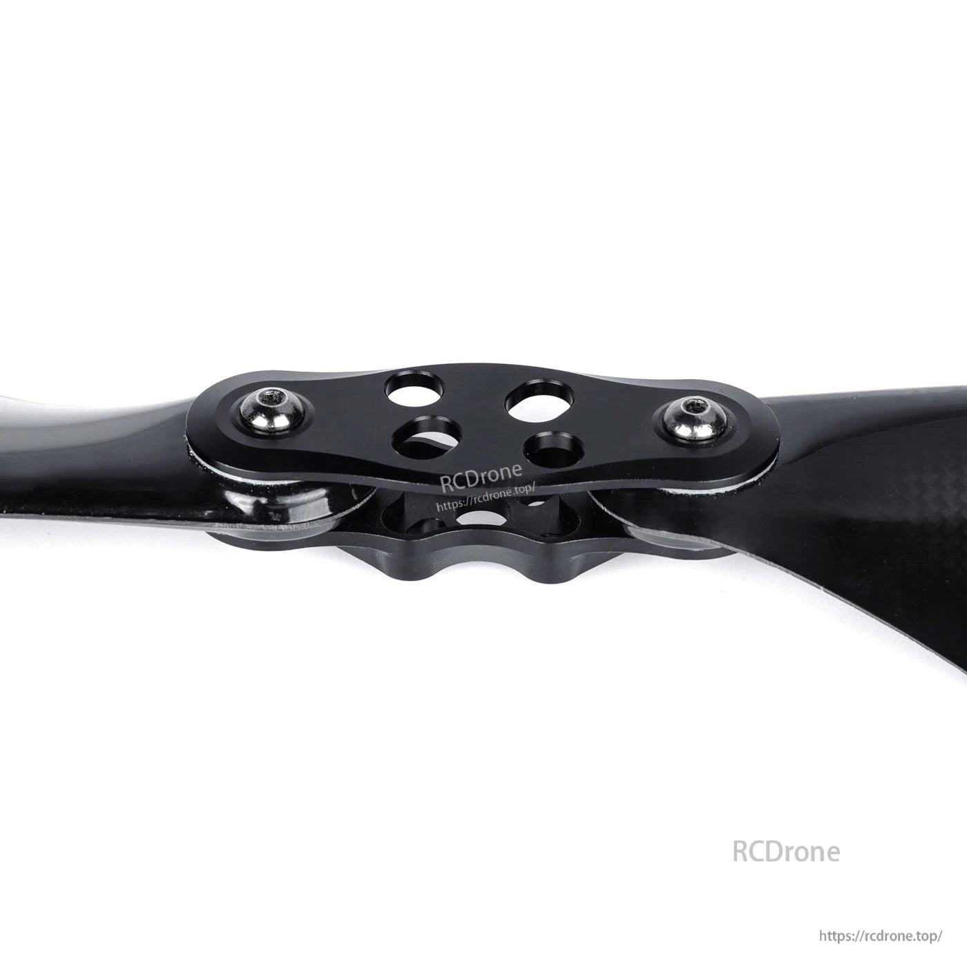 Glossy black carbon fiber folding propeller with metal hub plate, mounting holes, and screws close-up