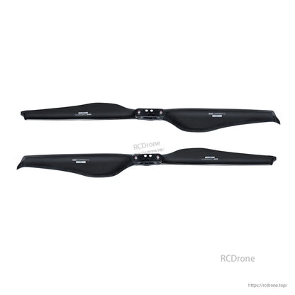 Pair of glossy carbon fiber folding propellers with center hub mounting plate for UAV or drone use
