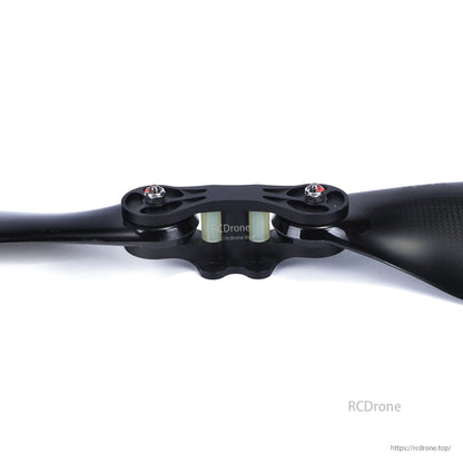 Close-up of MAD FLUXER Pro glossy carbon fiber folding propeller with central hub and mounting bolts