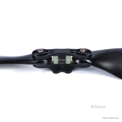 Carbon fiber folding propeller with central hub mount and two blades, close-up of the clamp and bolts