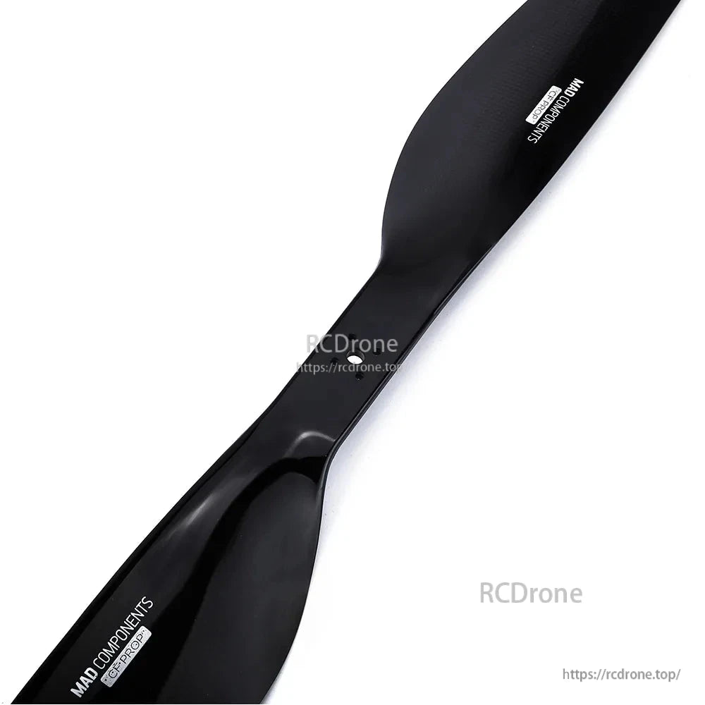 Glossy black carbon fiber drone propeller blade with MAD COMPONENTS branding, close-up view