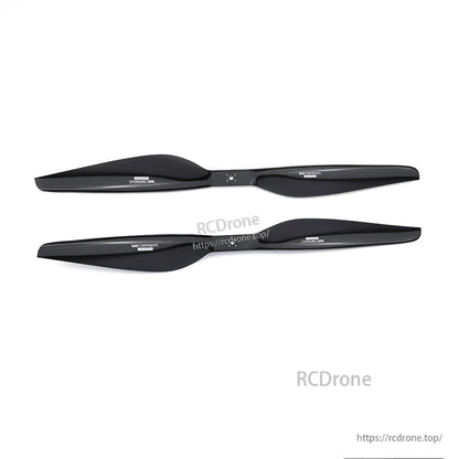 Pair of black two-blade carbon fiber propellers for RC aircraft, with center hub holes and printed markings