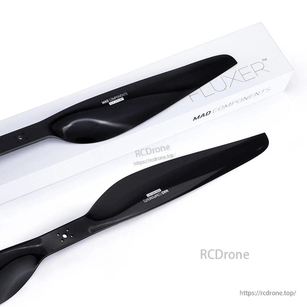 Pair of black carbon fiber drone propellers on Fluxer/MAD Components packaging, one CW and one CCW