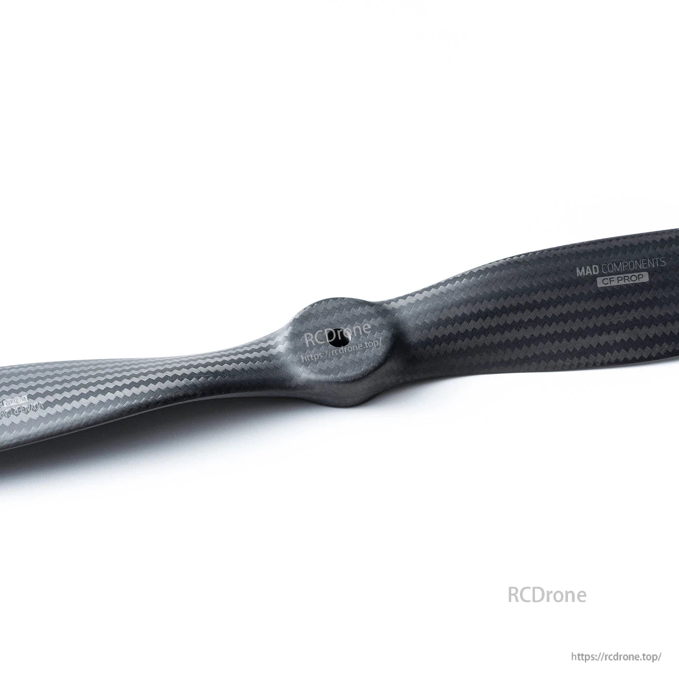 Close-up of MAD Components carbon fiber fixed-wing drone propeller showing hub and woven blade finish