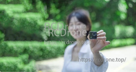 AiKUCAM NANO 1 Mini Action FPV Camera held in hand outdoors, compact pocket-size design