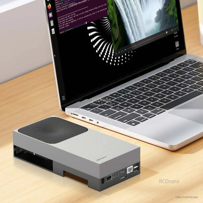 Jetson AGX Thor device connected beside a laptop on a wooden desk, showing compact desktop setup