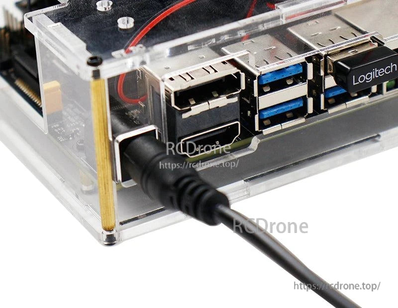 DC barrel plug connected to Jetson Nano board power jack in acrylic case, close-up