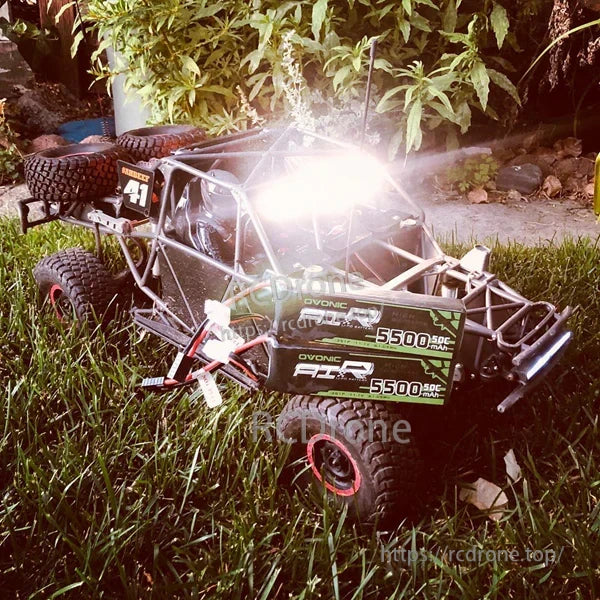 OVONIC 3S 11.1V 5500mAh 50C LiPo battery pack with Deans plug next to RC off-road buggy