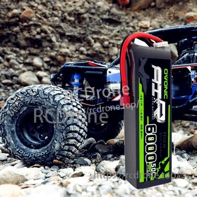 OVONIC 4S 14.8V 6000mAh 50C LiPo Battery with leads next to an RC rock crawler truck
