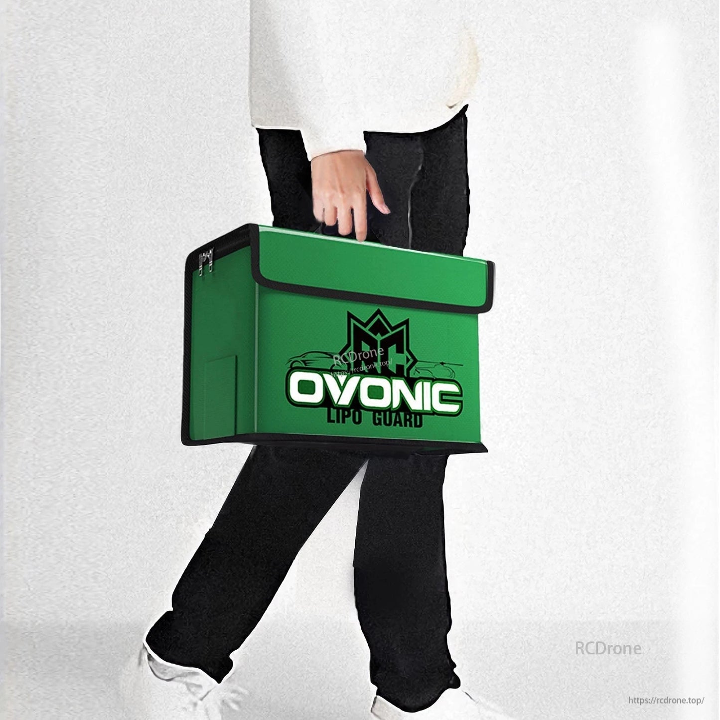 Person carrying the OVONIC green battery safety bag by hand
