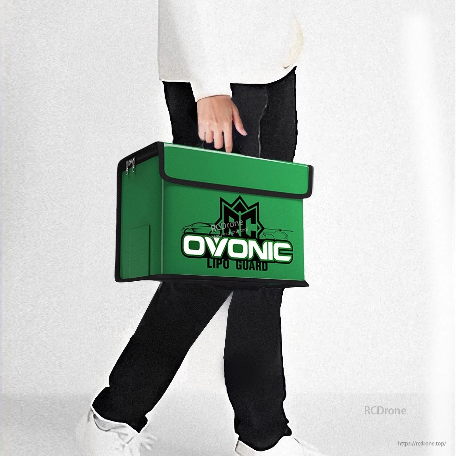 Person carrying the OVONIC green battery safety bag by hand