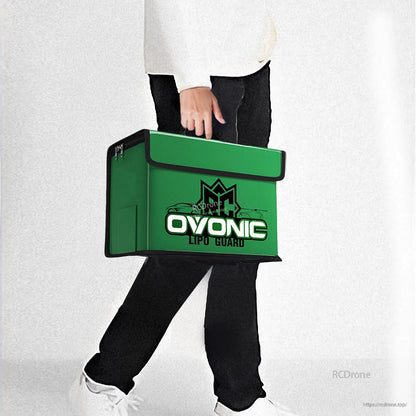 Person carrying the OVONIC green battery safety bag by hand