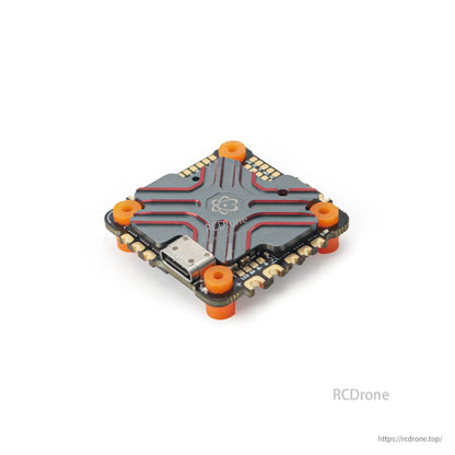 AIO flight controller installed with orange soft mounting grommets, angled top view
