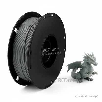 Gray filament spool with small dragon figurine sample print beside reel