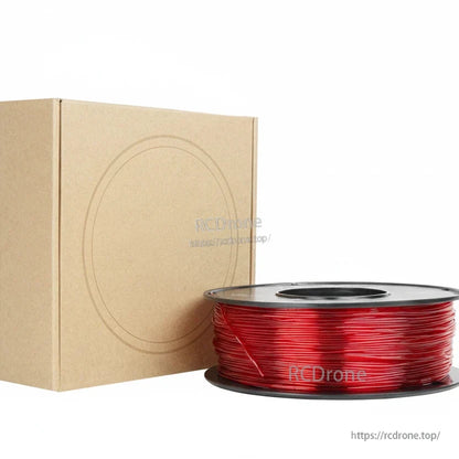 Red 3D printing filament spool beside a plain cardboard storage box