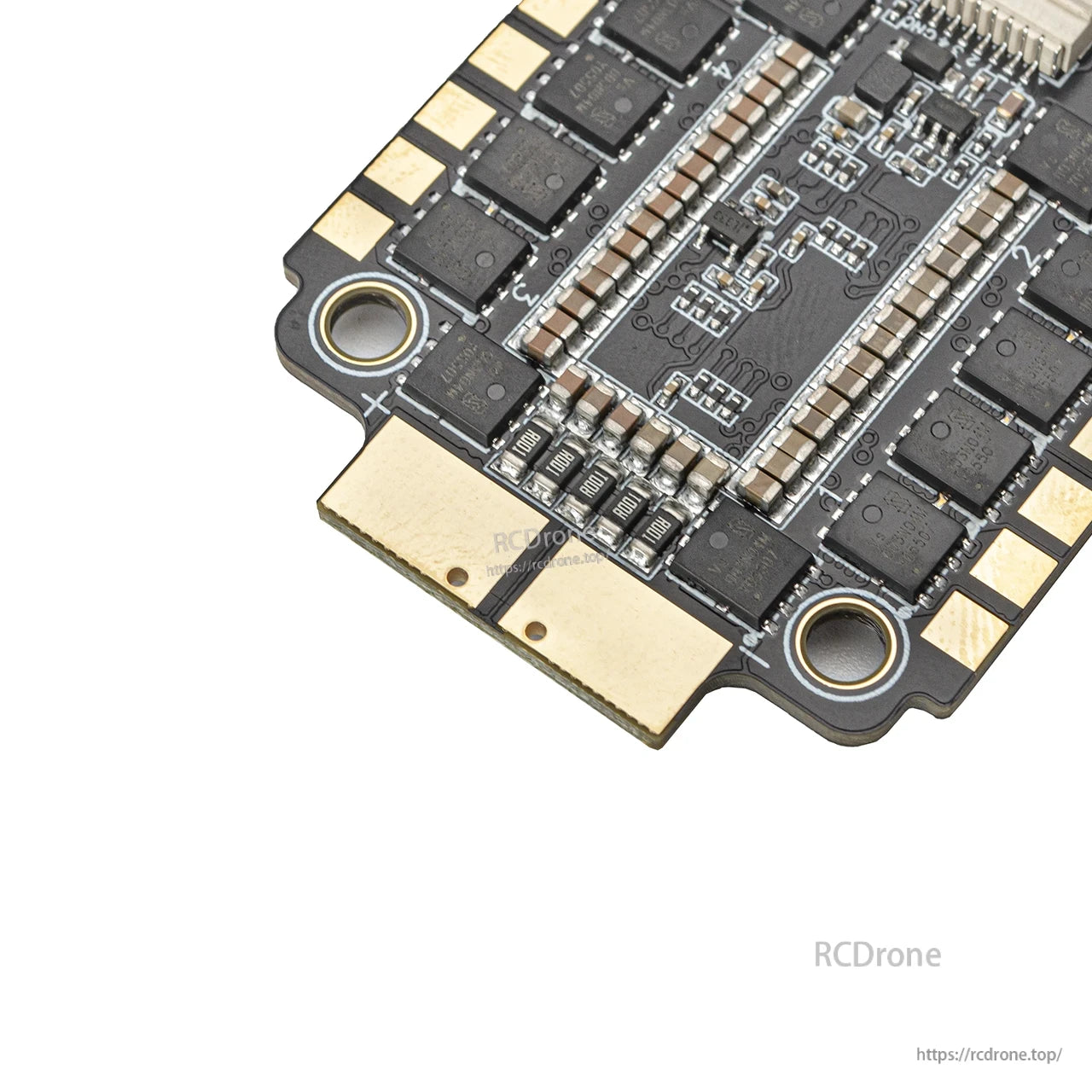 Close-up of motor output solder pads and capacitor bank on the 4-in-1 ESC