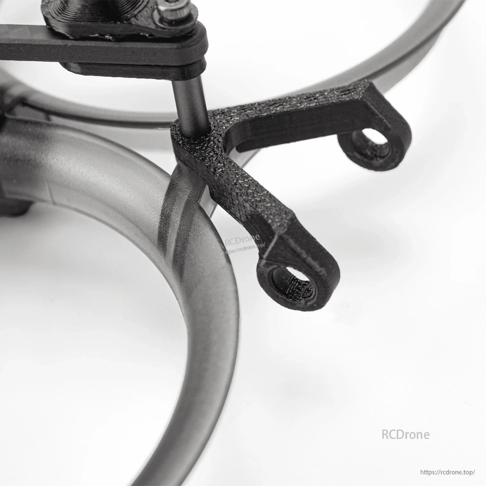 Close-up of carbon fiber arm tip and mounting holes beside duct ring