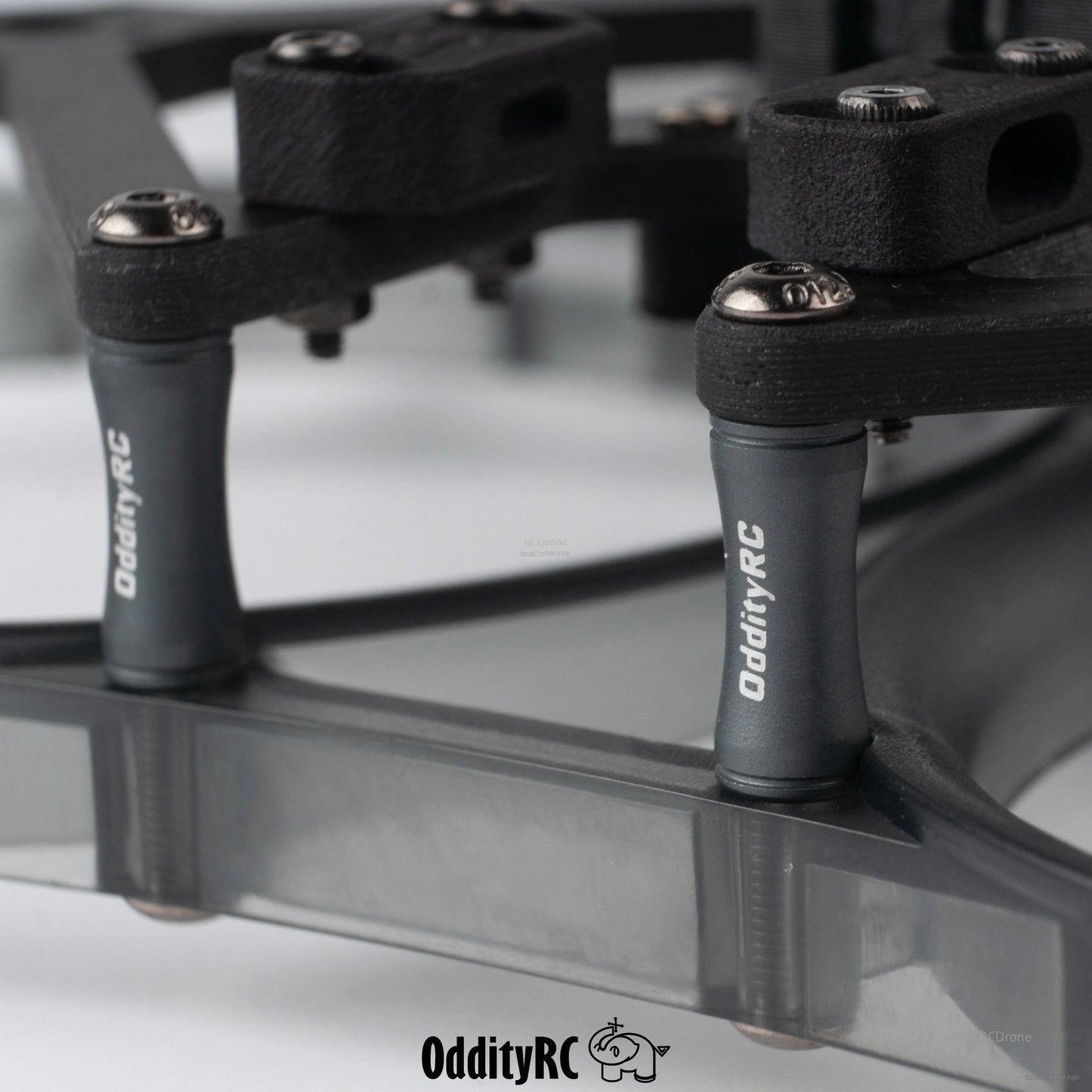 Close-up of OddityRC standoffs and hardware on smoke gray prop guard ring