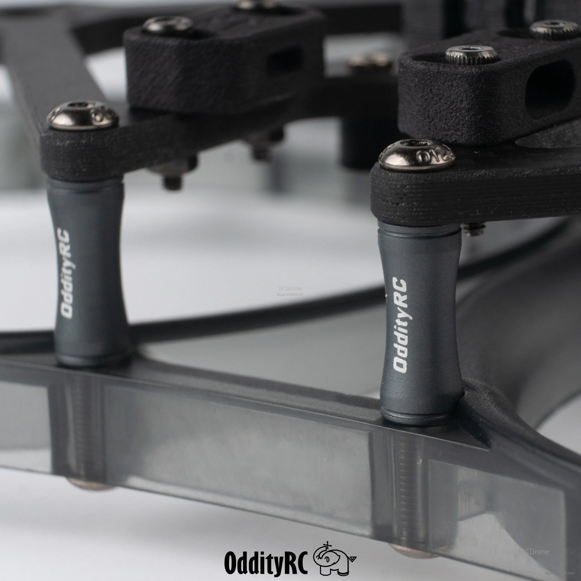 Close-up of OddityRC standoffs and hardware on smoke gray prop guard ring